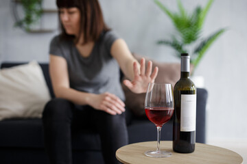 healthy lifestyle concept - young woman refusing glass of wine with palm gesture