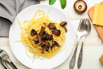 Plate with tasty pasta and mushrooms on table
