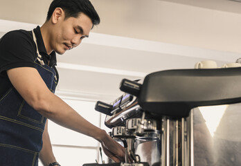 The young barista is determined to make coffee meticulously.