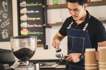 The young barista is determined to make coffee meticulously.