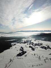 snow covered mountains aerial view with road and forest