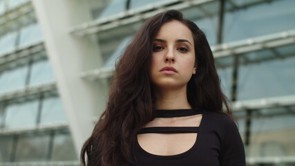 Portrait woman looking at camera at street. Woman walking in dress outdoor