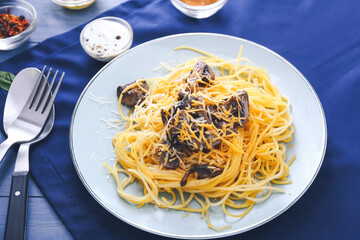 Plate with tasty pasta and mushrooms on table