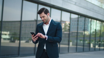 Fototapeta premium Close up man using mobile phone at street. Male celebrating victory outdoor