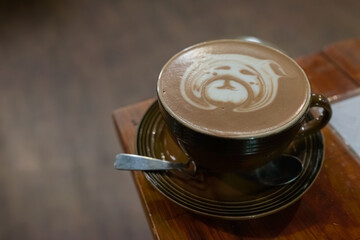 Cute animal bear face latte or Cocoa art in brown cup on wood table.