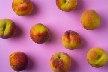 Fresh peaches on a pink background. View from above.