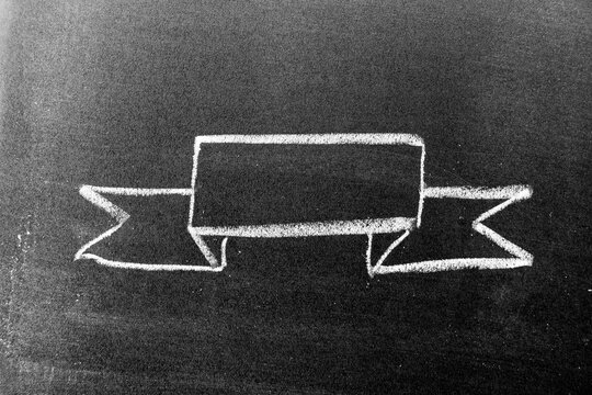 White chalk hand drawing in blank award ribbon banner shape on blackboard background