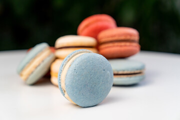 multicolored macarons from natural ingredients and colors on white table.