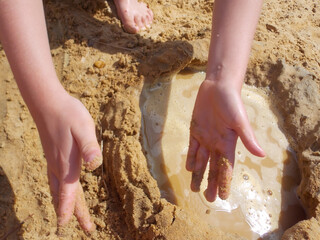 
hands and feet of a girl in the sand