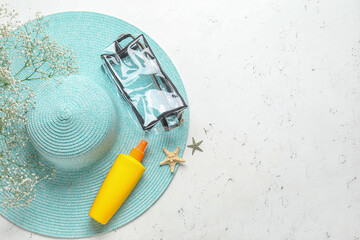 Bag with sunscreen cream and hat on white background