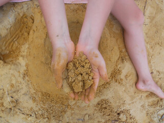 
hands and feet of a girl in the sand