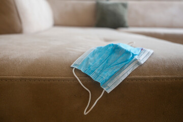 Face Medical mask on the sofa at home. Quarantine concept. coronavirus