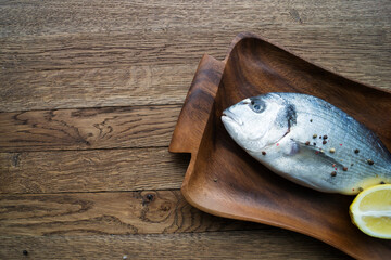 Two rainbow trout on a board, with herbs , ready for cooking.