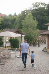 Fototapeta na wymiar Father walking with sun outdoors. Happy family. Boy in straw hat