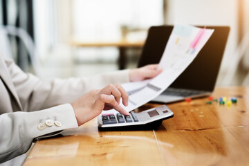 Fototapeta premium bookkeeper using calculator with computer laptop, budget and loan paper in office. Business accounting concept.