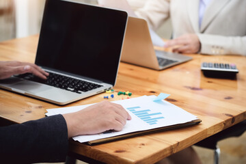 businessman pointing research data document and businesswoman using computer laptop for research or Marketing development in budget of company.