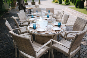 Served table set at summer terrace. Cutlery in cafe. Green background