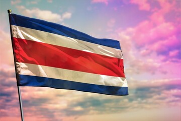 Fluttering Costa Rica flag on colorful cloudy sky background. Prosperity concept.