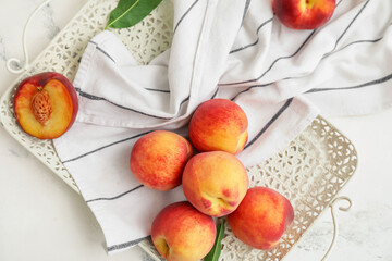Tray with ripe peaches on white background