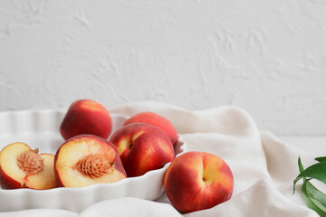 Tray with ripe peaches on table