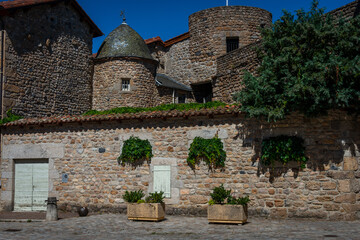 Stone cross and Flowers ,in the medieval town  of Malzieu , lozere France .a stage in the way of compostelle a long distance walk .