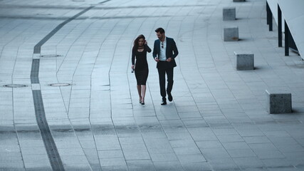 Business couple talking in stylish clothing. Business couple walking at sidewalk