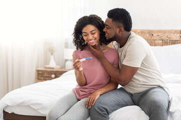 Loving black man kissing his pregnant wife or girlfriend