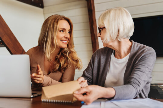 Portrait of businesswoman consulting with retired woman at home