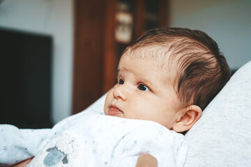 Lovely newborn baby girl with a warm pajama at home