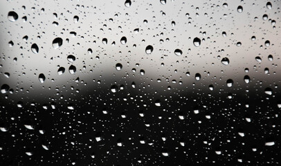 Raindrops on the window pane slowly flowing down