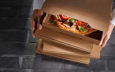 Hands of a chef packing an order of pizzas