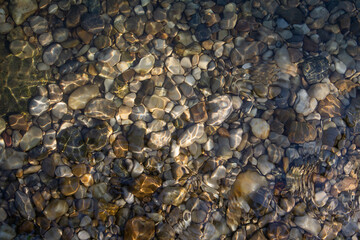 Texture of river pebbles under water.