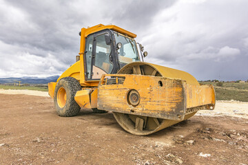 Yellow steamroller performing ground leveling work