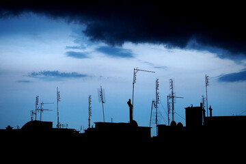 Dachy z antenami na tle nieba po burze we Wrocławiu, Polska