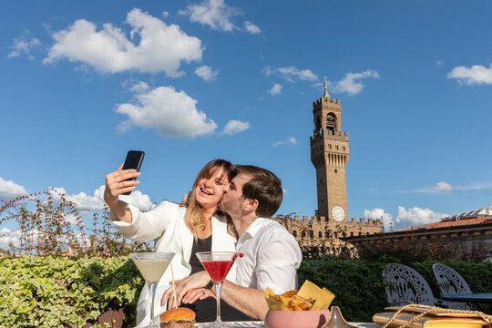 Delighted couple taking selfie during date in garden