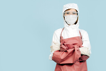 Surgeon standing with her hands crossed with red leather apron and sleeves