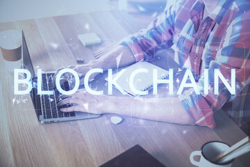 Blockchain theme hologram with man working on computer on background. Concept of crypto chain. Double exposure.