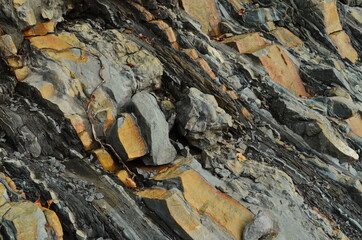 Naklejka premium Rock layers - a colorful formations of rocks stacked over the hundreds of years. Interesting background with fascinating texture.