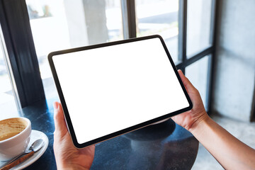 Mockup image of a woman holding black tablet pc with blank white desktop screen