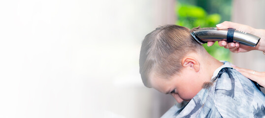 Panoramic view Close up pretty school boy trendy haircut at bright modern barbershop.Copy space.