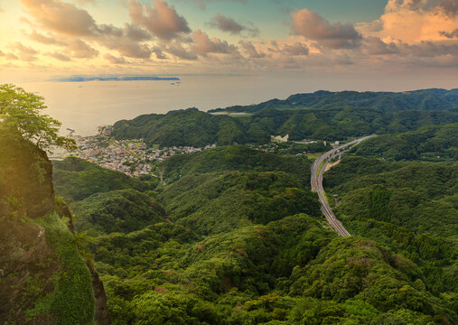 Sunset sky on the Uraga Channel and Kanaya fishing village with the Futtsu-Tateyama Road in the mountains of Boso peninsula from the cliff of the Mount Nokogiri quarry.