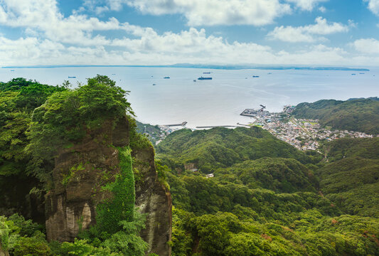 Tanker boats sailing on the Uraga Channel with the Kanaya fishing village from the cliffs of the stone quarry of Mount Nokogiri in the Boso peninsula.
