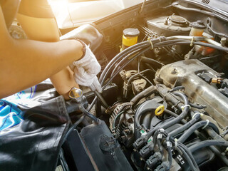 Auto mechanic with tool working check and fixed an old car engine at service station,change and repair before drive