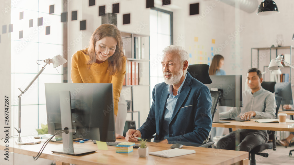 Poster handsome middle aged creative engineer sitting at the desk working on desktop computer has discussio