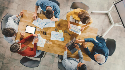 Startup Meeting Room: Team of Entrepreneurs sitting at Conference Table Have Discussions, Solve...