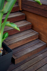Natural wooden stairs going on a terrace deck     