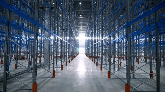 Wide View Empty Warehouse With Metal Shelves. Large Modern Industrial Building From The Inside With Rows Of Racks. Big Steel Structures of Pallet Frame in the Sorting Center of Logistics Company 4k