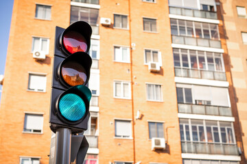Semáforo en verde con edificio de ladrillo visto al fondo con luz diurna