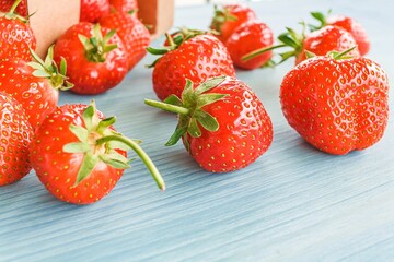 Ripe strawberries are scattered on the table. red berry on a wooden background . packing the product in a box