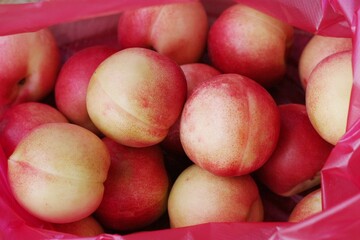 Ripe juicy nectarines in a red bag